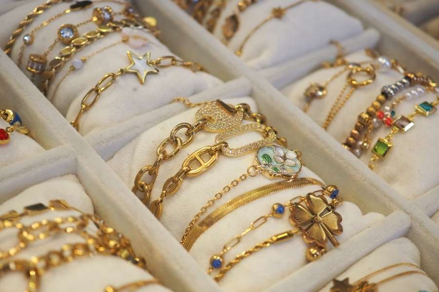 Une collection variée de bijoux dorés et de bracelet femme présentés dans un écrin de rangement.